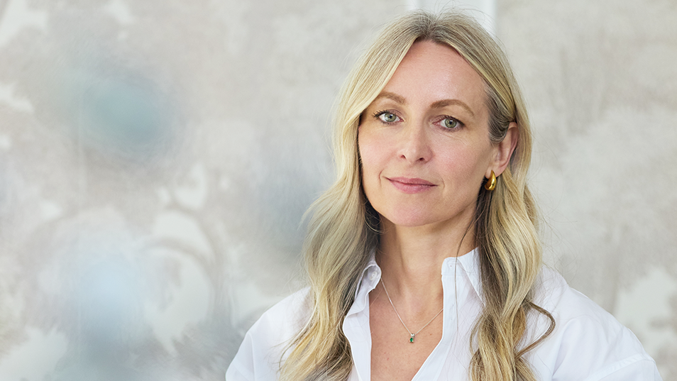 Woman with blonde hair wearing a white shirt against a light background